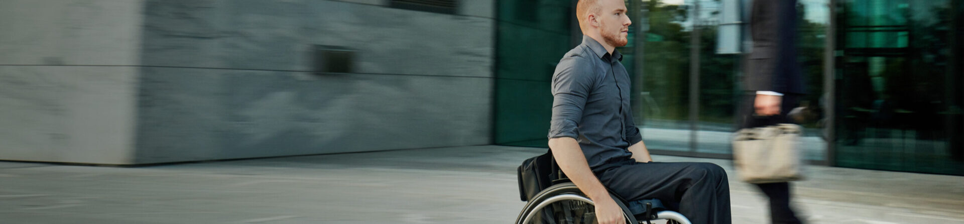 Man in wheelchair on city street.