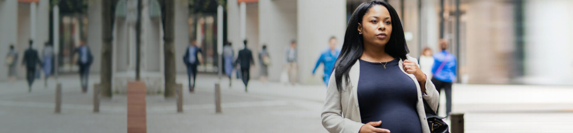 Pregnant woman walking on street.